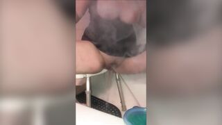 Busty lady squirts in the tub while smoking