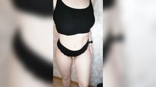 A girl with a perfect figure is trying on different black panties.